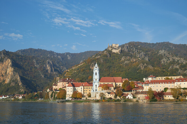 Stadt Dürnstein im Herbst. Zu sehen sind Schloß Dürnstein, die Burgruine und das Stift Dürnstein mit dem blauen Turm.