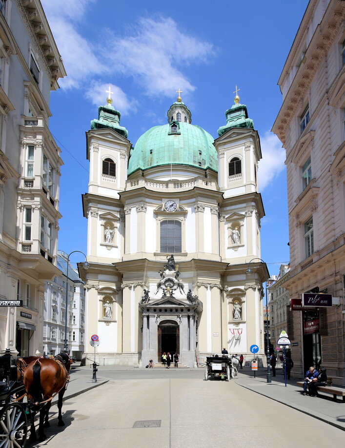 Hauptfassade bzw. Südwestansicht der Peterskirche im 1. Wiener Gemeindebezirk Innere Stadt. Der erste Kuppelbau des barocken Wien wurde ab 1701/02 errichtet. Die Planung und der Baubeginn (Fundamente) erfolgte unter Gabriele Montani. Nachdem dieser als Festungsarchitekt nach Madrid zog, setzte ab 1703 sehr wahrscheinlich Johann Lucas von Hildebrandt den Bau nach veränderten Plänen fort.