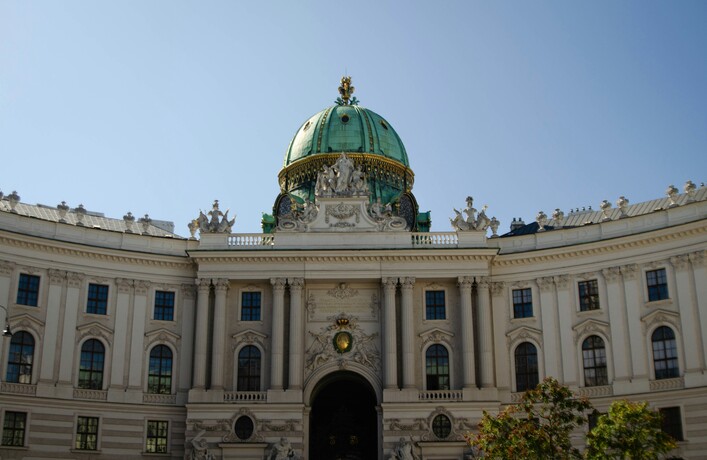 Grand building with a green dome under blue sky