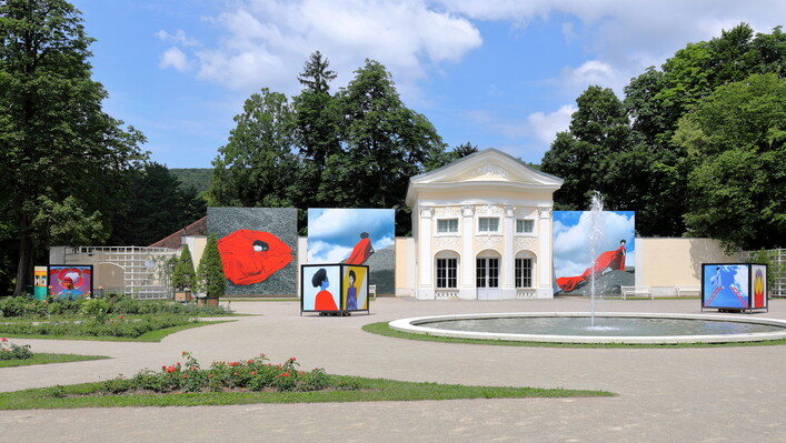 Pavillon der ehemaligen Orangerie im Doblhoffpark in der niederösterreichischen Stadt Baden mit Fotos der Open-Air Fotoausstellung Fotofestival La Gacilly-Baden 2018.Der ehemalige Schlosspark des Schlosses Weikersdorf ist nach dem Adelsgeschlecht Doblhoff benannt, die von 1741 bis zum Ankauf durch die Stadtgemeinde Baden im Jahr 1966 im Besitz des Schlosses und Parks waren. 1969 wurde ein Rosarium in dem rund 8 Hektar großen Park in Kooperation mit der Stadtgemeinde, den österreichischen Baumschulen und dem Architekt Viktor Mödlhammer eröffnet. 2018 wurden dabei ca. 600 Rosensorten präsentiert.