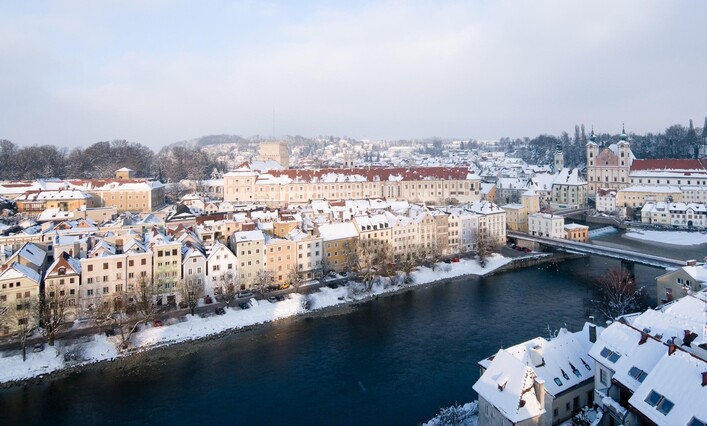 Blick auf den Enns Fluss und die verschneite Altstadt mit dem Schloss Lamberg.