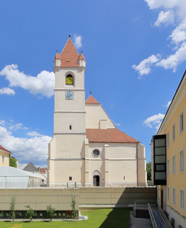 Westansicht des Domes St. Martin in der burgenländischen Landeshauptstadt Eisenstadt.Die dreischiffige spätgotische Hallenkirche wurde anstelle einer romanischen Kleinkirche errichtet. Um 1460 erfolgte der Neubau unter Johann Sybenhirter; 1468 war der Chor fertiggestellt und 1522 das Langhaus mit dem Turm. 1960 erfolgte die Erhebung der Stadtpfarrkirche zum Bischofsdom.Ursprünglich war westseitig eine Doppelturmfassade geplant, jedoch ausgeführt wurde nur der nordseitige und südseitig wurde der Turm nur bis auf eine Höhe von etwa des Langhauses realisiert.