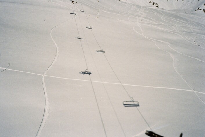 A group of people riding skis down a snow covered slope