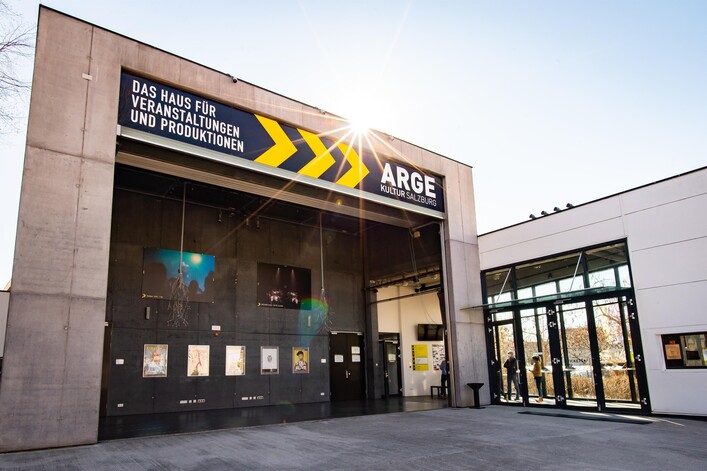 Ein modern gestaltetes Gebäude mit großem Eingang. Darüber steht der Schriftzug "ARGE - Das Haus für Veranstaltungen und Produktionen".