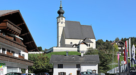 Das Ortszentrum der oberösterreichischen Gemeinde Steinbach am Attersee mit der in erhöhter Lage errichteten röm.-kath. Pfarrkirche hl. Andreas im Hintergrund.