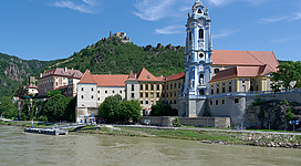 Dürnstein Abbey on the bank of the Danube in Wachau Valley. Ruins of the Dürnstein Castle in the background