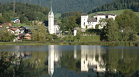 Ansicht von Goldegg über den Goldegger See. Pfarrkirche und rechts Schloss Goldegg.