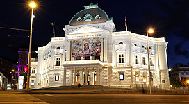 a large white building with a green dome and a cross on top