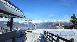 A snow covered ski slope with a ski lift in the background