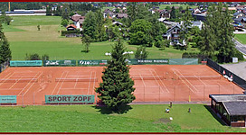 Abgebildet sind die Tennisplätze und das Clubhaus im Vordergrund.