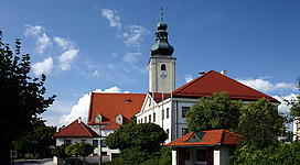 Municipality Wiesmath in Lower Austria. – The photo shows the municipality office of Wiesmath. In the background the parish church Saints Peter nnd Paul.