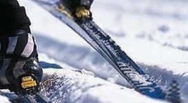 Ein Wintersportler fährt auf Skiern durch den frischen Schnee. Die Skier sind gut im Schnee verankert und zeigen die Spuren der Bewegung.