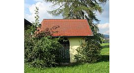 Blick auf die Kapelle, seitlich Sträucher