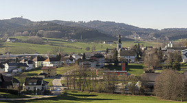 Ampflwang, Gesamtansicht. Links oben der Aussichtsturm Göblberg. Darunter die Remise des Lokparks. Rechts die Kirche, die Feuerwehr und das Reitzentrum. Im Hintergrund der Robinson Club.
