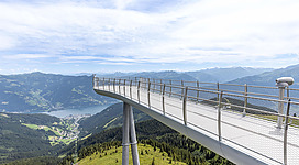 Eine beeindruckende Aussichtsplattform über den Bergen mit weitem Blick auf das Tal. Die klare Himmel und die grüne Landschaft bieten eine atemberaubende Kulisse.