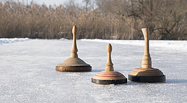 Stockschießen in Lohnsburg\nZu sehen ist eine Natureisfläche mit drei Holzeisstöcken.
