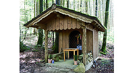 Blick auf eine Holzkapelle im Wald