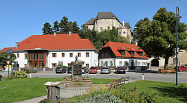 Ortszentrum der niederösterreichischen Marktgemeinde Albrechtsberg an der Großen Krems mit der Burg im Hintergrund und dem Kriegerdenkmal im Vordergrund.