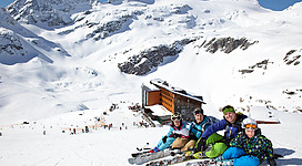 Familie mit Skiern vor schneebedeckten Bergpanorama am Weißsee.