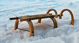 Auf dem Bild ist ein Schlitten im Schnee erkennbar