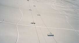 A group of people riding skis down a snow covered slope