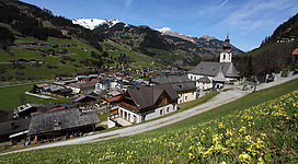Die Pfarrkirche Großarl im Frühling, im Hintergrund Arlspitze und Höllwand der Ankogelgruppe.