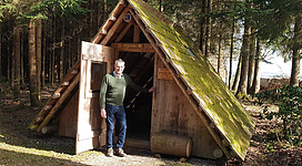 Bild zeigt den Erbauer Anton Schönberger vor der Hütte