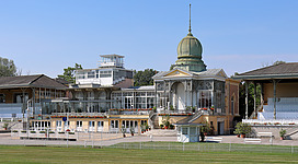 Die Hof-Tribüne der Galopprennbahn Freudenau im 2. Wiener Gemeindebezirk Leopoldstadt.Die Galopprennbahn ist eine in der Freudenau 1839 eröffnete Anlage. 1858 findet in Gegenwart von Kaiser Franz Joseph die Einweihung von 2 Tribünen statt, die nach Entwürfen des Ringstraßen-Architekten Carl Hasenauer von seinem Bruder, dem Hofzimmermeister Christoph Hasenauer, errichtet wurden. 1870 erfolgte die Einweihung der „Hof-Tribüne“, die aus der „Hof-Loge“, der Clubloge und der „westlichen“ Tribüne besteht, und vom Budapester Architekten Adolf Feszty (1846–1900) entworfen wurde. 1883 zerstörte ein Brand teilweise die Tribünen. Für die Wiederinstandsetzung wurde der Architekt Josef Drexler beauftragt. Im Anschluss wurden nach seinen Plänen bis 1887 auch noch das Totalisator-Gebäude, das Verwaltungs- sowie Stallgebäude errichtet. 1967 kaufte der Staat um 7,6 Mio. Schilling die Gebäude auf dem Rennplatz. Von 1983 bis 1986 fand eine aufwendige Renovierung der Tribünenanlage statt. 1991 Gründung der IRM-Interrace Rennbahn Management Ges.m.b.H., die die Anlage mit den Stallungen „verwaltet“. De facto finden keine Rennen mehr statt. Die Hoftribüne wird für Events aller Art genutzt und die Rasenfläche innerhalb der 2.800 km langen Rennbahn als Golfplatz.