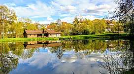 Märchenteich und Holzhütte bei Sonnenschein