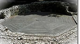 Ratzlburg - Ausgrabung in Braunau am Inn: Eine schneebedeckte Berglandschaft mit einem einfachen Gebäude in der Mitte. Das Gebäude hat ein traditionelles Dach mit einem Glockenturm oben. Die Umgebung sieht sehr bergig und natürlich aus.